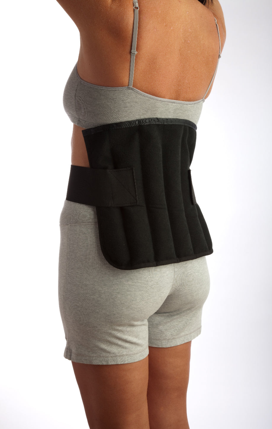 sideview of a person wearing a large black wrap on the lower back 